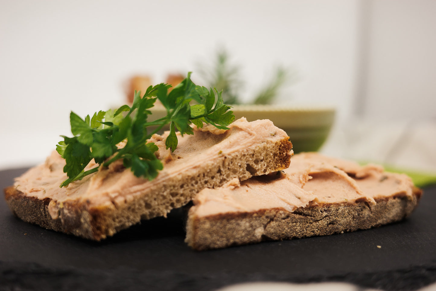 Vegane Naturaufstrich auf zwei Brothälften, auf einer ist noch Petersilie.