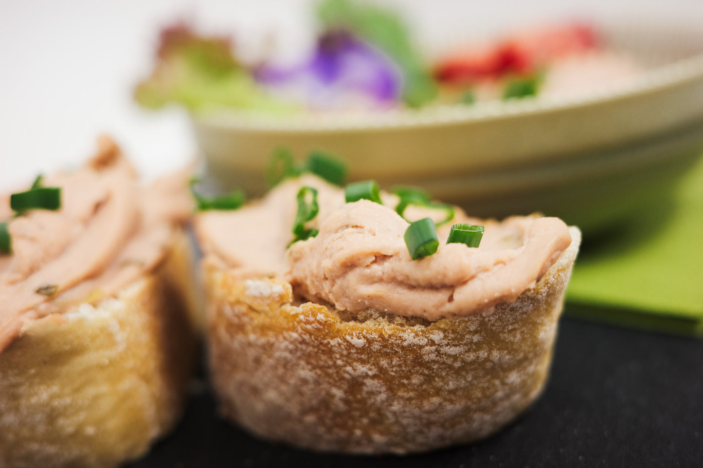 Röstzwiebel Aufstrich vegan auf einer Baguette Scheibe und Schnittlauch oben drauf.