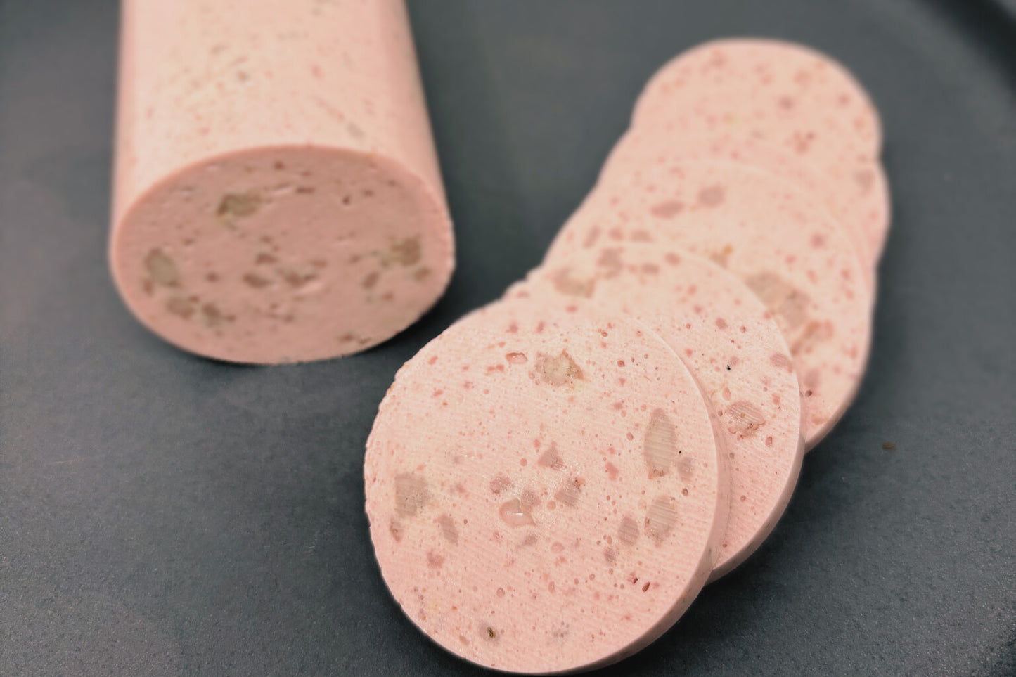 Veganer Tofu Lyoner in Scheiben aufgeschnitten.