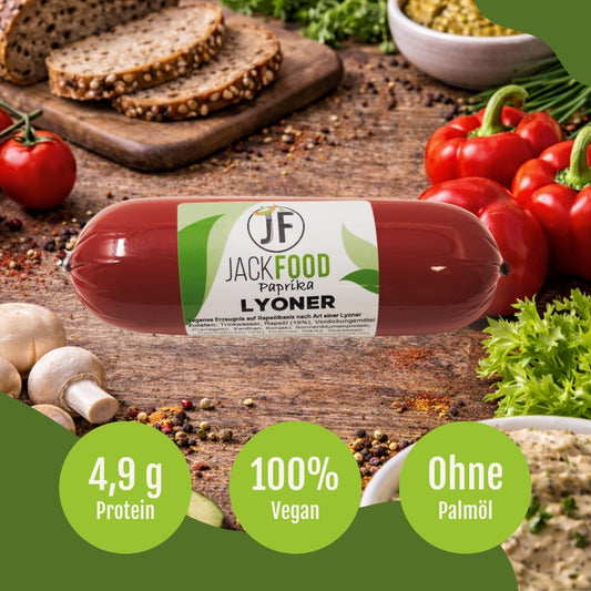 Die pflanzliche Lyoner Alternative von JackFood mit Paprika. Im Hintergrund sind rote Paprika, Tomaten und Brot.