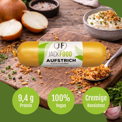 JackFoods veganer Leberwurst Aufstrich mit Röstzwiebeln. Frische Zwiebeln befinden sich im Hintergrund und Röstzwiebeln auf einem Löffel im Vordergrund.