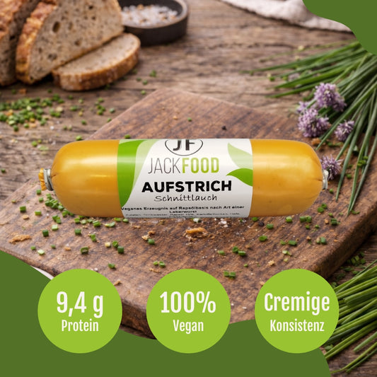 Der vegane Leberwurst Aufstrich mit Schnittlauch von JackFood. Frisches Brot und ein Bund Schnittlauch sind im Hintergrund.
